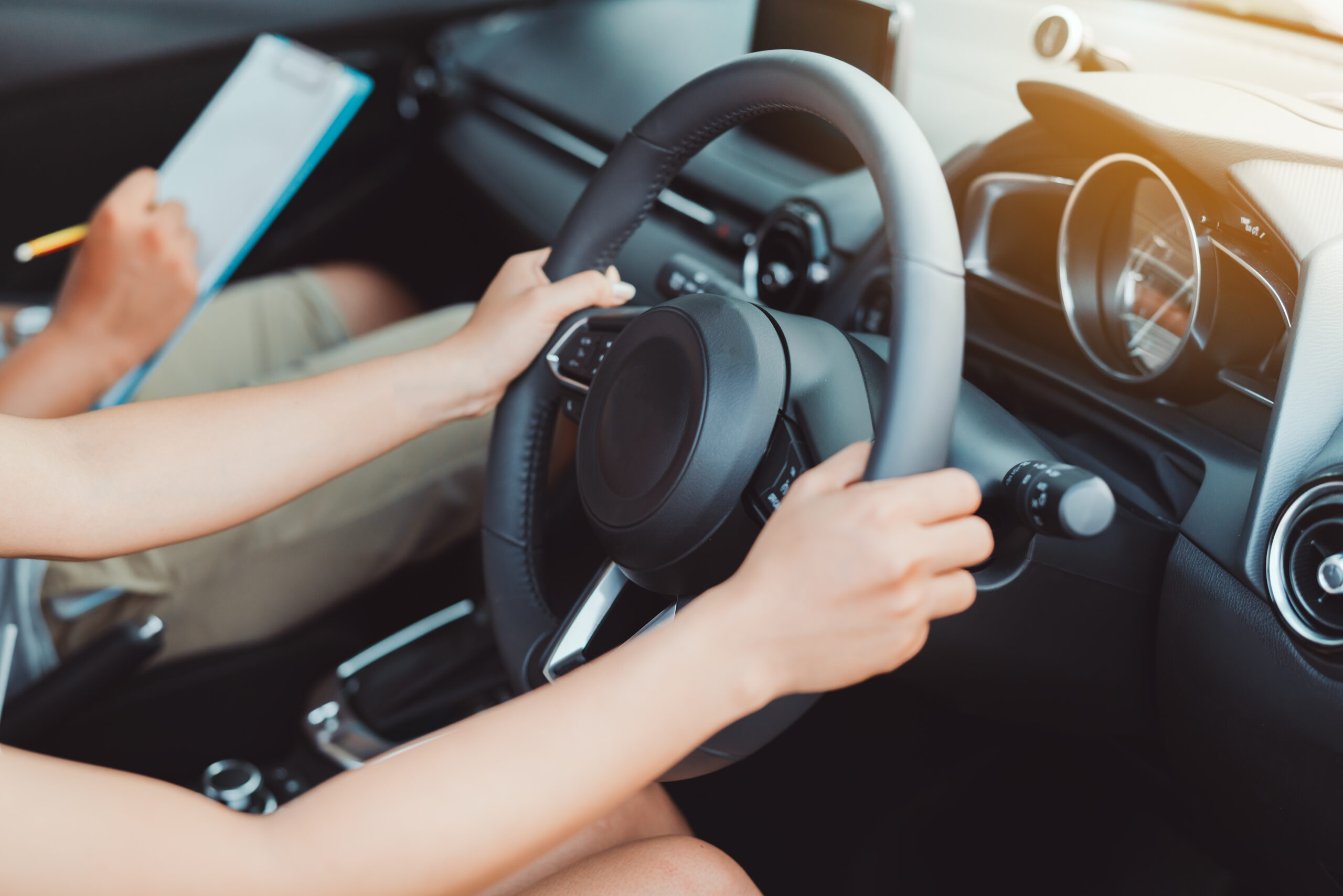 woman holding wheel of car, learning how to drive. Best places to practice driving concept image.
