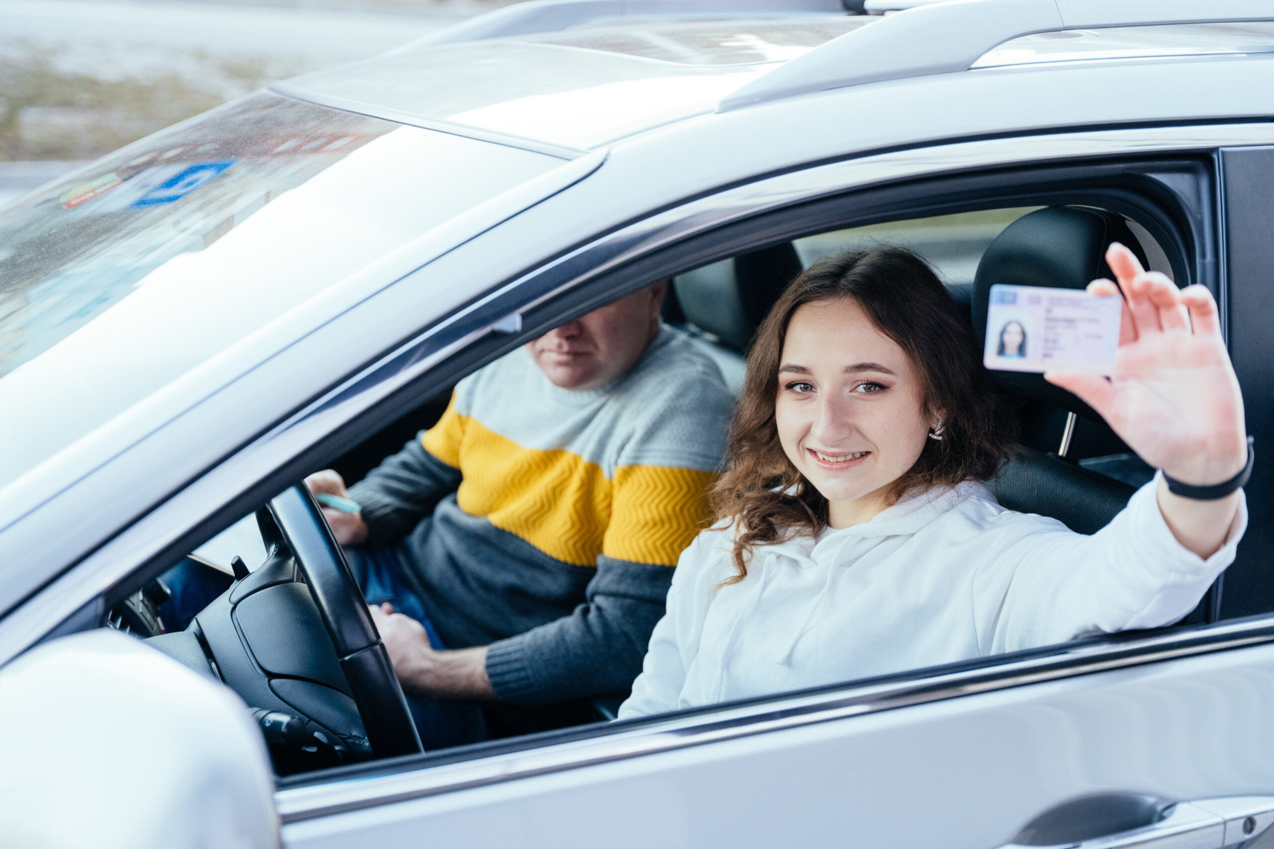 girl holding her license after passing her driving test