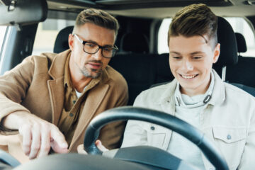 Father teaching son how to drive using Teen Driver Technology